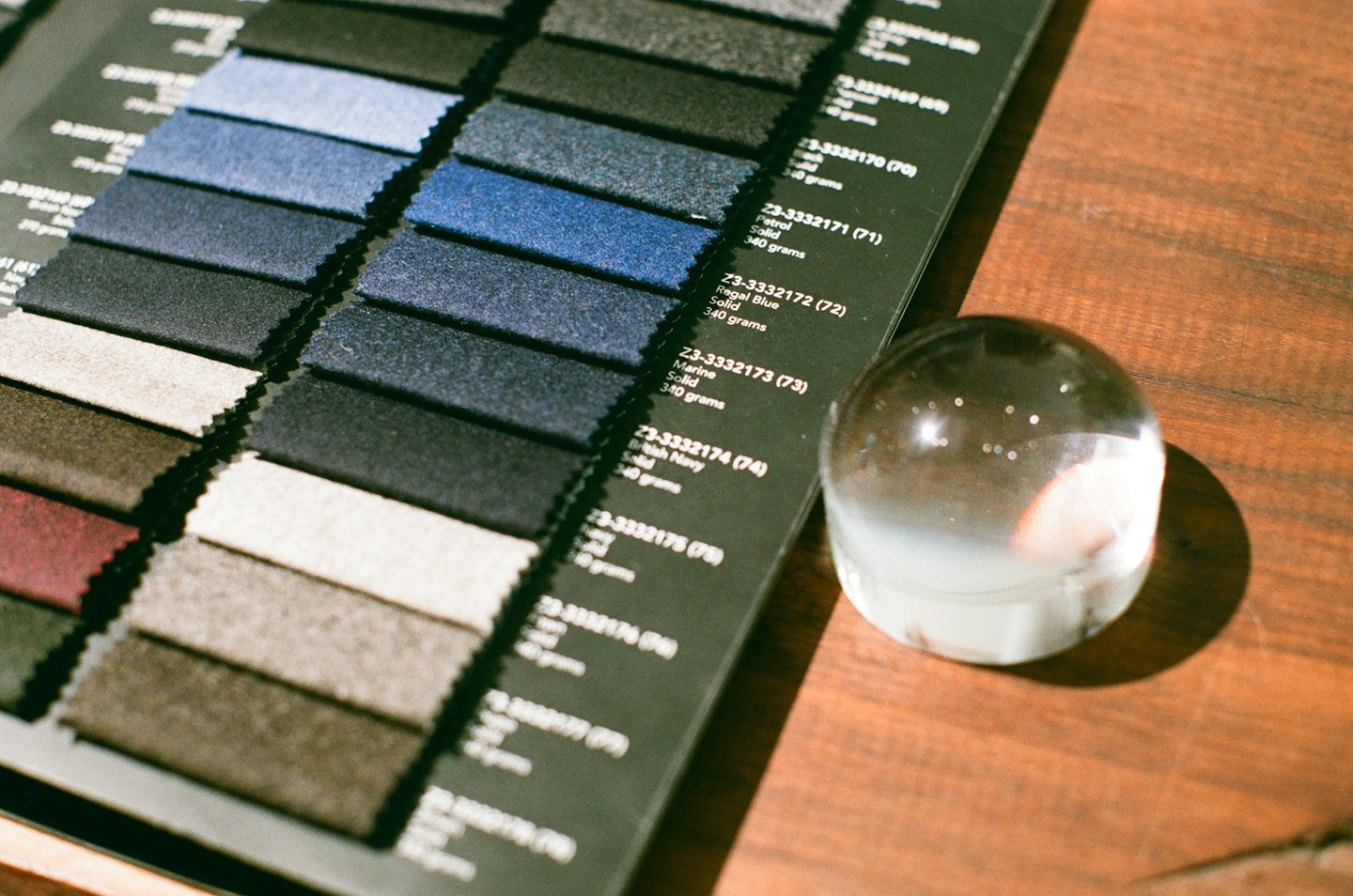 Fabric swatch book with blue, grey, and brown samples on a table.